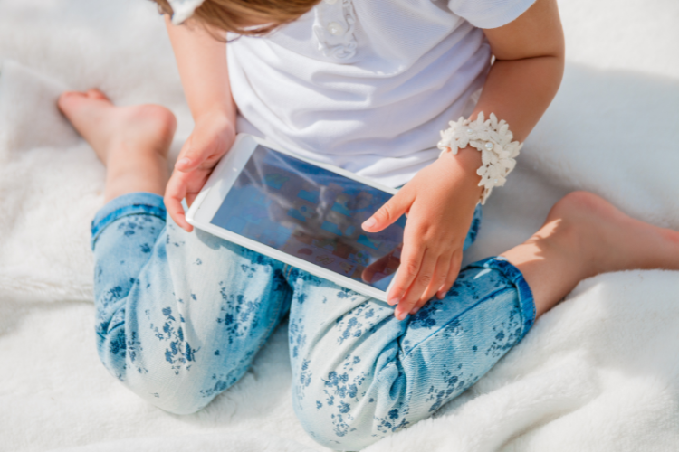 A child playing on a device. What to pack for a motorhome holiday